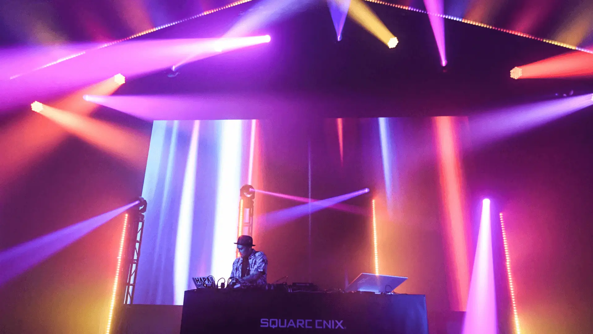 DJ at mixing desk under purple lights